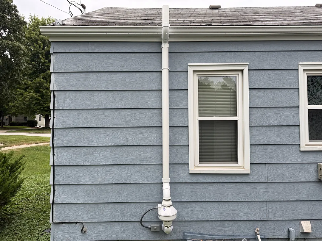 finished radon mitigation system on the side of a home